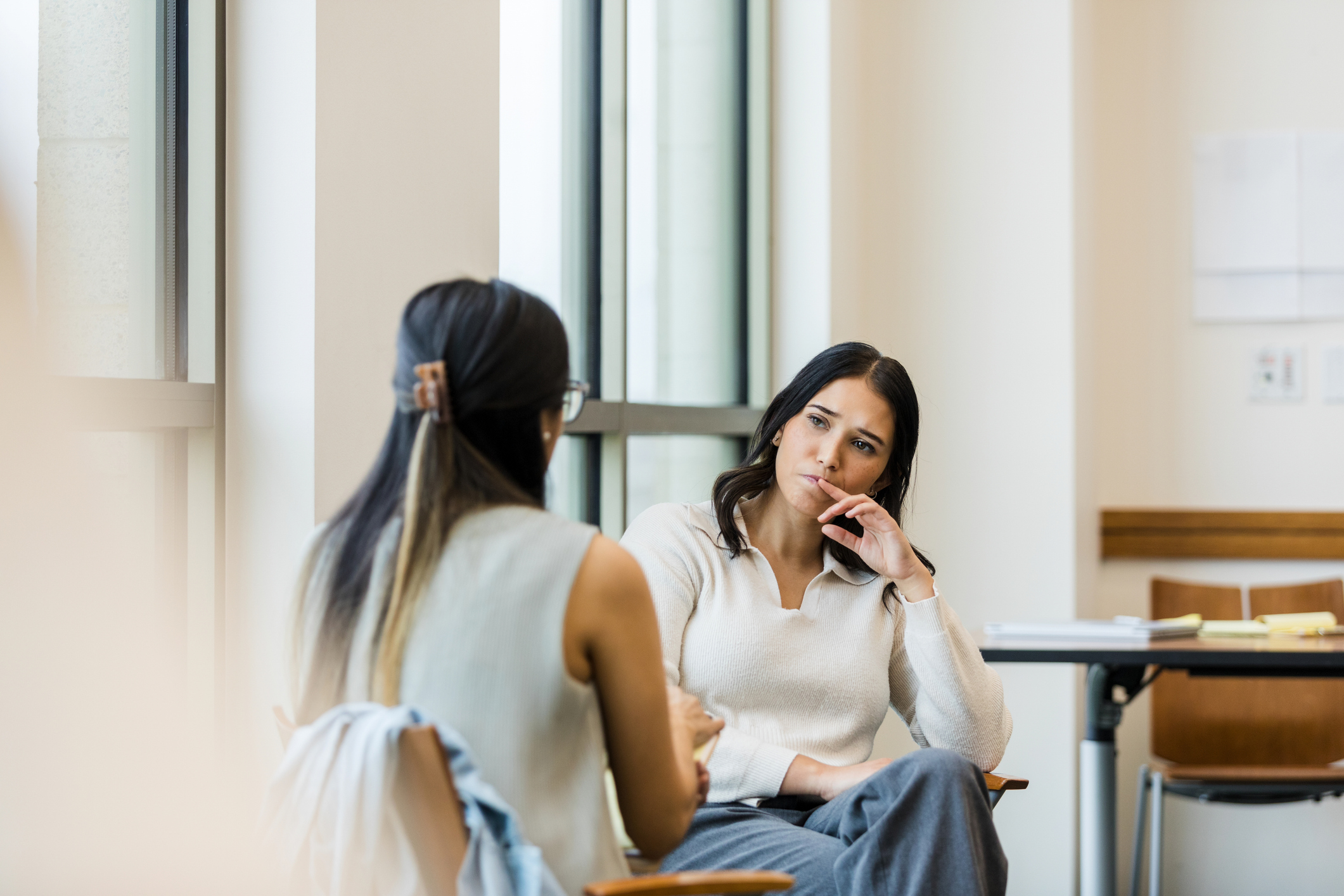 Dos mujeres conversando sentadas en una sala